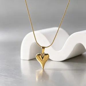 Minimalistischer 3D-Herzanhänger an einer eleganten Schlangenknochenkette aus Gold.