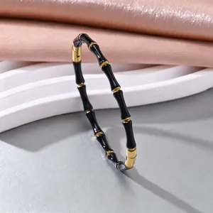 Detailansicht eines schwarz-goldenen elastischen Armbands aus Edelstahl im Bambus-Stil für Damen