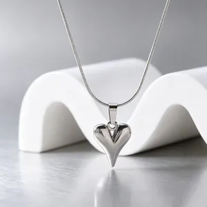 Nahaufnahme eines minimalistischen 3D-Herzanhängers aus Edelstahl an einer Schlangenkette