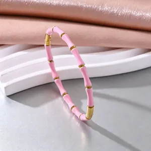 Detailaufnahme eines elastischen Bambus-Armbands aus rosa Emaille und vergoldetem Stahl