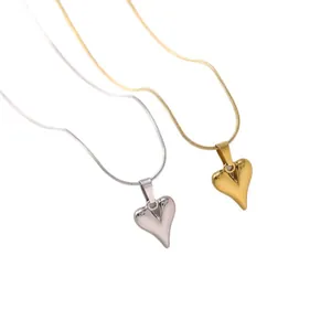Detailansicht von Gold- und Silber-Herzanhängern an dünnen Edelstahl-Schlangenketten.