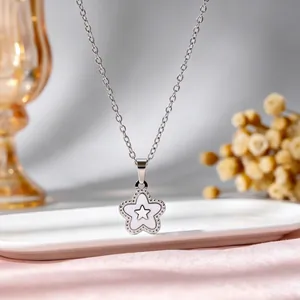Macro-opname van een roestvrijstalen ketting met een witte emaille sterrenhanger.
