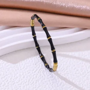 Detailweergave van de zwart-gouden emaille bamboe segment armband van rvs