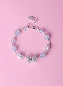 Detailed view of a lavender amethyst beaded bracelet with a silver butterfly charm and tag.