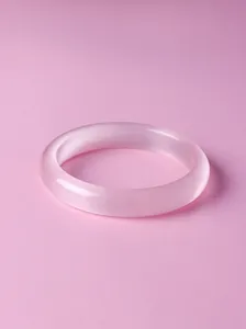 Elegant close-up of a translucent light pink quartz bangle with a smooth polished finish