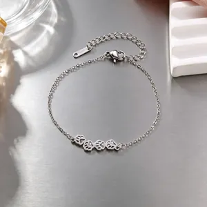 Detalle de pulsera de acero plateado con cuatro huellas de gato caladas