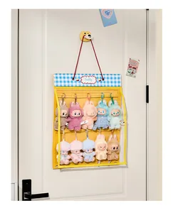 Detail of plush toy organizer hanging on door with Labubu dolls behind clear cover