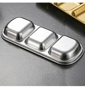 Close-up of stacked stainless steel 3-grid seasoning dishes with metallic finish