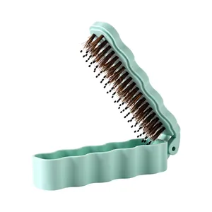 Portable mint green folding boar bristle hairbrush with a stylish wavy shell design