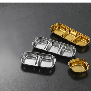 Macro view of gold and silver stainless steel divided sauce dishes with multiple grids.