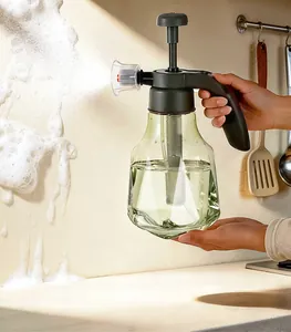 Detailed view of a green multi-functional foam sprayer cleaning the kitchen wall