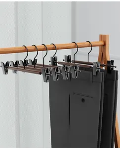 Detailweergave van zwarte beukenhouten broekhangers met verstelbare clips op rek.
