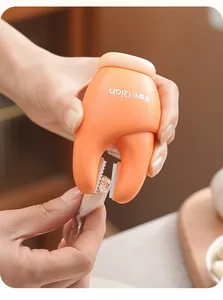 Close-up detail of a crab-shaped manual garlic peeler tool trimming a fresh garlic clove