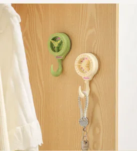Detail view of creative clock-shaped suction cup hooks on a wooden door surface.