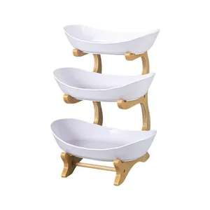 Elegant three-tier tiered fruit serving rack with white oval bowls and wooden stand