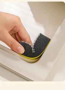 Close-up of a flexible double-sided sponge cleaning the narrow edges of a kitchen sink basin