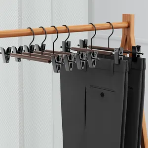 Premium beukenhouten en metalen broekhangers met antislipclips aan houten rek