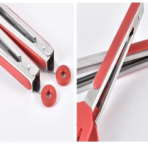 Close-up view of stainless steel and red silicone kitchen tongs showing handle lock detail