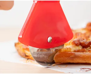 Close-up of a stainless steel wheel pizza cutter with red handle cutting through a pizza.
