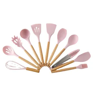 11-piece pink silicone kitchen utensil set with natural wooden handles on white background