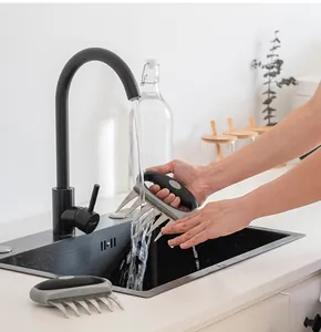 Reinigen der Fleischkrallen aus Edelstahl unter einem modernen Küchenwasserhahn