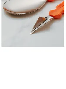 Close-up of stainless steel pumpkin carving tool with sharp serrated blade and orange handle