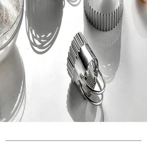 Detailed close-up of a fluted stainless steel cookie cutter with handle on white surface