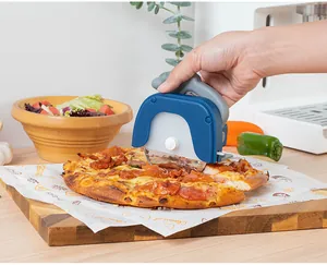 Verwendung eines blauen Pizza-Rollers zum Schneiden einer frischen Pizza auf Holz