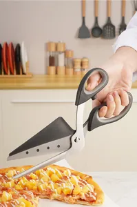 Detailed view of stainless steel pizza scissors with spatula cutting a fresh pizza