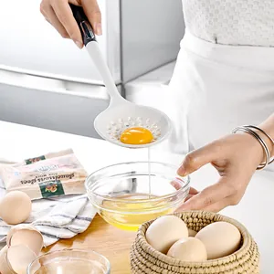 Premium white silicone slotted spoon egg separator tool used in a kitchen setting