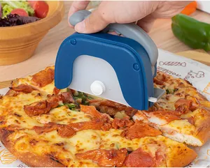 Detailansicht eines blauen Pizzaschneiders mit Schutzhülle beim Schneiden einer Pizza