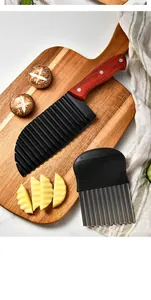 Détail de deux coupe-frites ondulés sur une planche de bois avec des pommes de terre