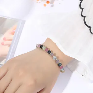 Close-up of colorful tourmaline magnetic bracelet with gold wire wrapping on wrist