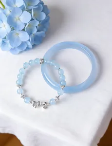 Detail shot of light blue beaded bracelet with silver bow and matching bangle