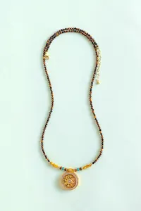 Detalle de collar de cuentas de ojo de tigre y cuarzo rutilado con colgante giratorio