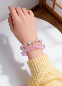 Close-up of pink crystal bead bracelet with silver bow and matching bangle charm.