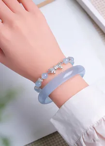 Detail view of lavender chalcedony bangle and beaded bracelet with silver bow