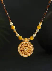 Detalle de collar de cuentas de ojo de tigre y cuarzo rutilado con colgante dorado