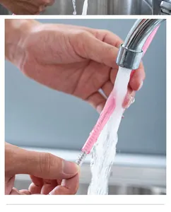 Close-up of a reusable pink silicone straw being cleaned with a small wire brush under water
