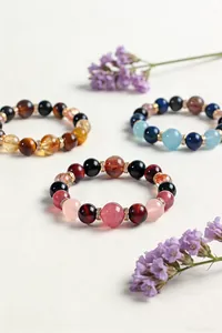 Primer plano de varias pulseras de cuentas de piedras naturales con adornos dorados