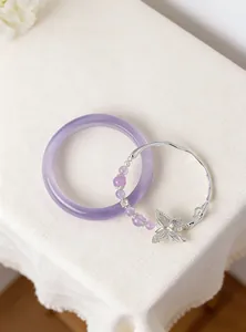 Detailed view of purple cat-eye bangle and elegant silver butterfly bead bracelet.