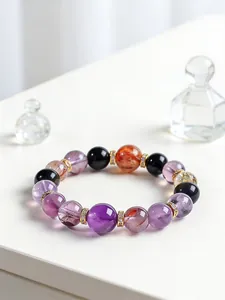 Vista detallada de la pulsera de cuentas de amatista natural y cuarzo fantasma para mujer.