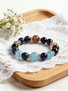 Primer plano de una pulsera de piedras naturales multicolores sobre encaje blanco