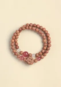 Detail of cedar wood double-loop bracelet with carved rose and strawberry crystal beads