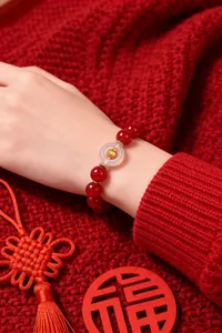 Close-up of red agate zodiac bead bracelet on wrist with white agate peace buckle