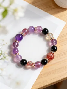 Detalle del brazalete de amatista natural y piedras super seven con espaciadores dorados