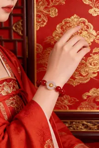 Detailed view of a natural red agate bracelet with white agate safety buckle on wrist