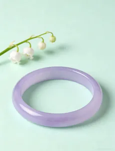 Lavender purple crystal bangle with smooth glossy finish and lily of the valley background
