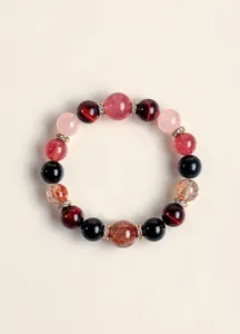 Primer plano detallado de una pulsera de lujo con cuentas de piedras naturales y cristales dorados