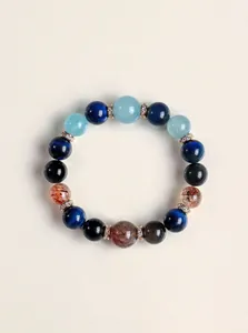 Primer plano de una pulsera de cuentas con piedras naturales, cuarzo rutilado y ojo de tigre.